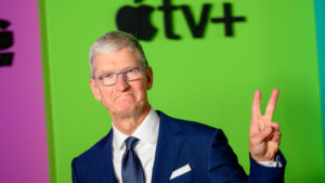 Apple CEO Tim Cook showing a peace sign with his left hand at a company event