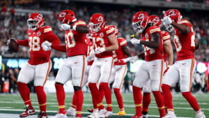 A row of seven Kansas City Chiefs players celebrating in the end zone after a touchdown